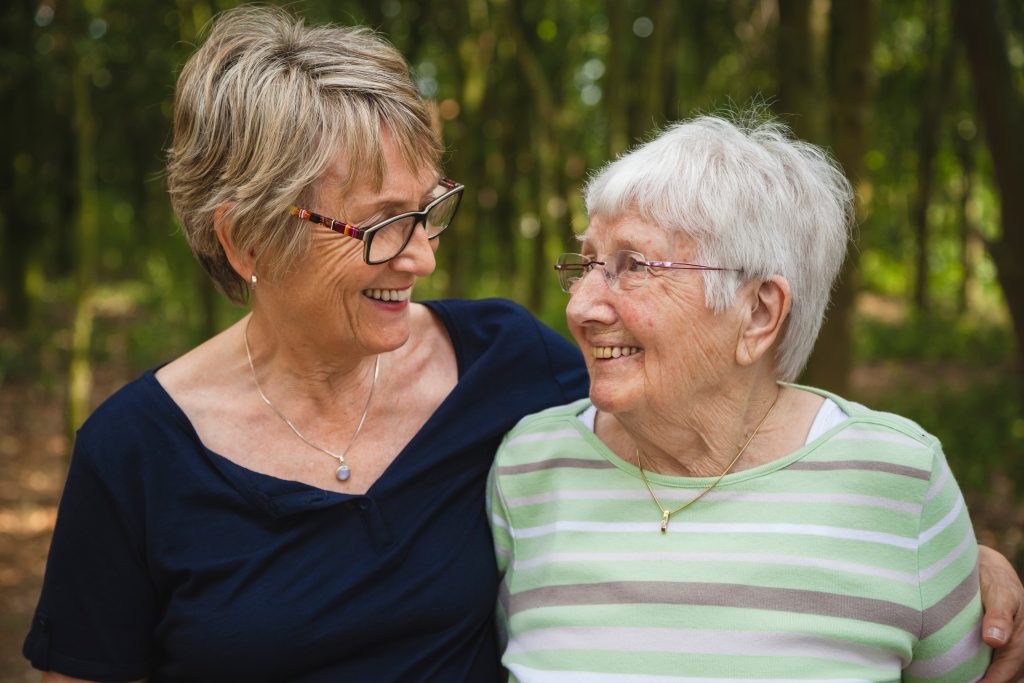Senior lady with her aged mother with dementia, embracing and sm